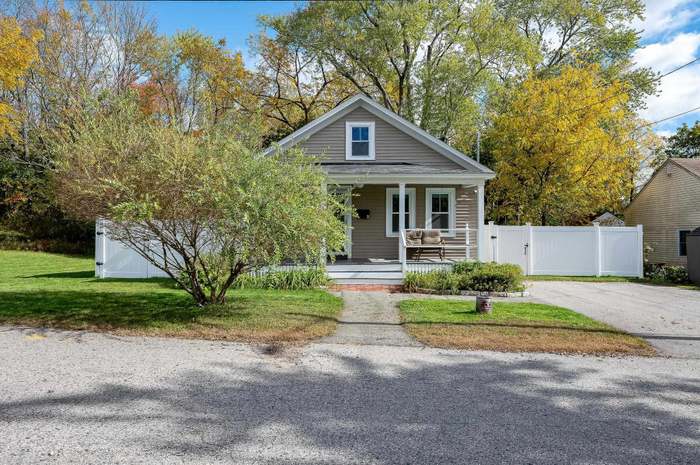 A house with a red door and a white car parked in front with the text "Call Jordan 479-857-7207".