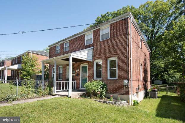 A house with a red door and a white car parked in front with the text "Call Jordan 479-857-7207".