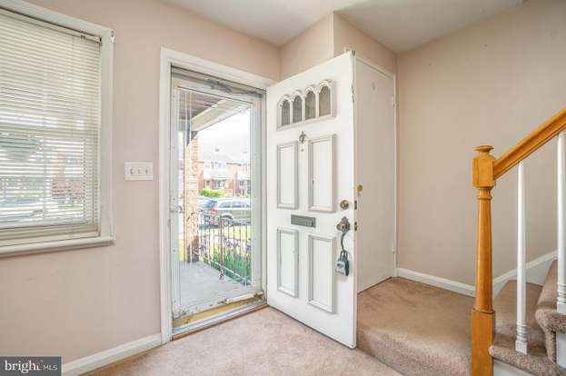 A house with a red door and a white car parked in front with the text "Call Jordan 479-857-7207".