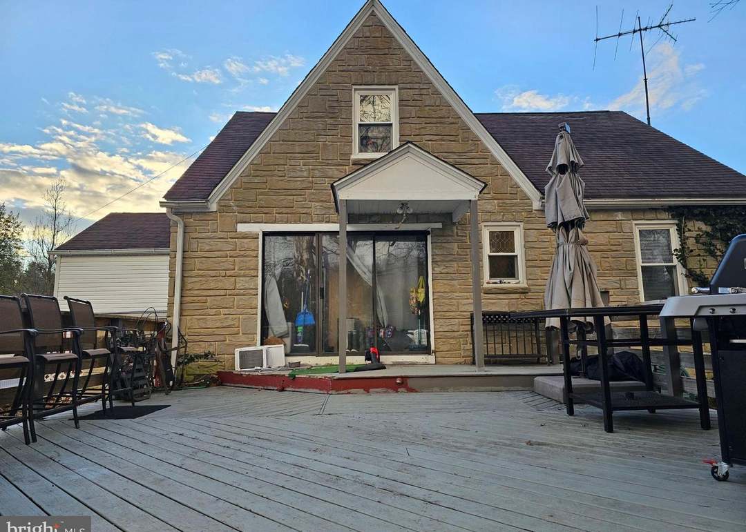 A house with a red door and a white car parked in front with the text "Call Jordan 479-857-7207".